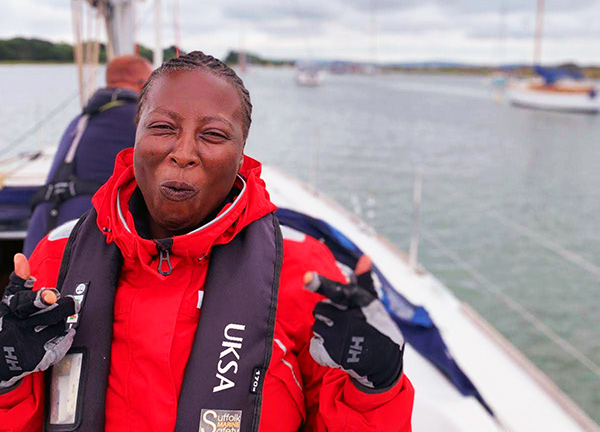 smiling woman standing on sailing yacht with an excited expression on her face