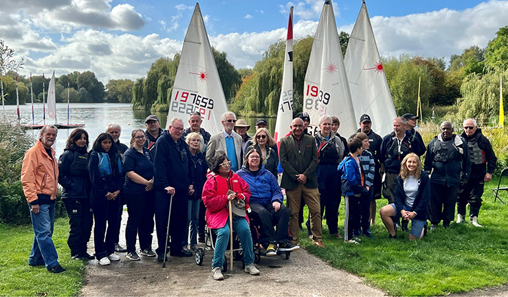 Group photo of LRYSA volunteers and members by the lake celebrating the opening of their new clubhouse with Mayor and Lord-Lieutenant their special guests for the day.