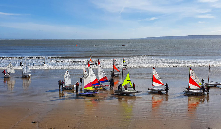 Young sailors launching from the beach on a sunny day at Filey SC for a NEYYTS event.