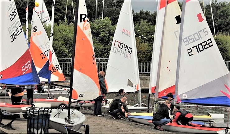 Junior sailors launching with help from parents at NEYYTS event, Yeadon SC, 2022