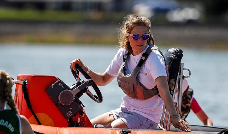 Women steering a powerboat.