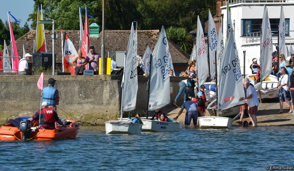 Row of dinghies launching down slip way at sailing club