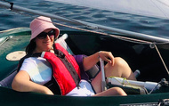 Juliette, looking relaxed and confident in a small boat, in the sun in Cardiff Bay