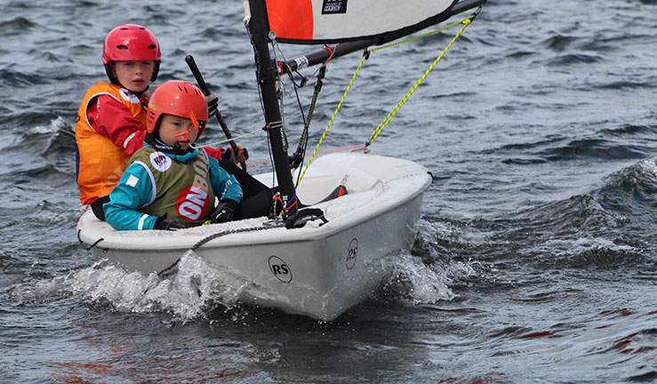 Mid shot of two children sailing a small water craft