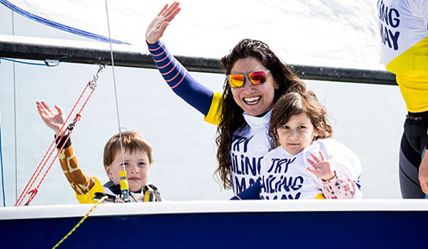 Mum and two children dinghy sailing and smiling 