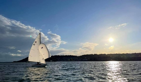 classic yacht sailing with sunset on the Menai Strait