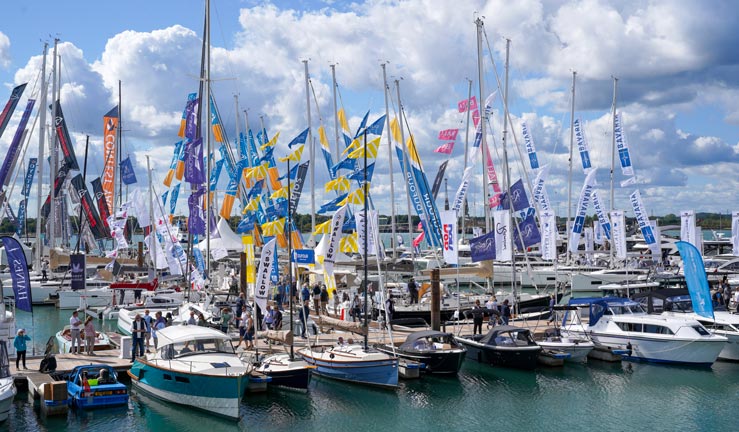 Yachts, motorboats and happy young visitors at Southampton International Boat Show. 