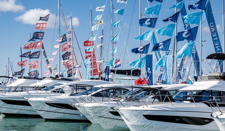 Yachts, motorboats and happy young visitors at Southampton International Boat Show. 