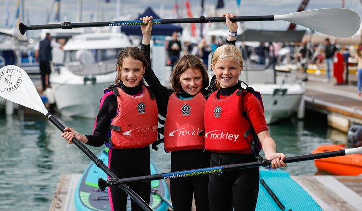Yachts, motorboats and happy young visitors at Southampton International Boat Show. 