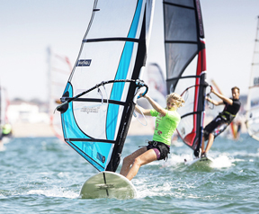 An image showing two people windsurfing on the water.