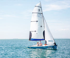 An image of a dinghy sailing on the water.