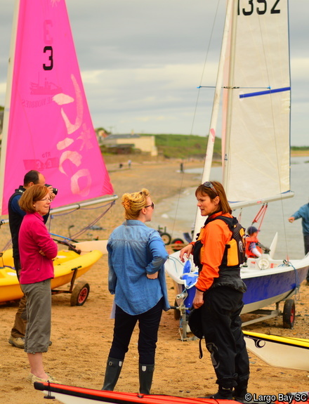 A group of volunteers on the beach amongst kayaks and dinghies