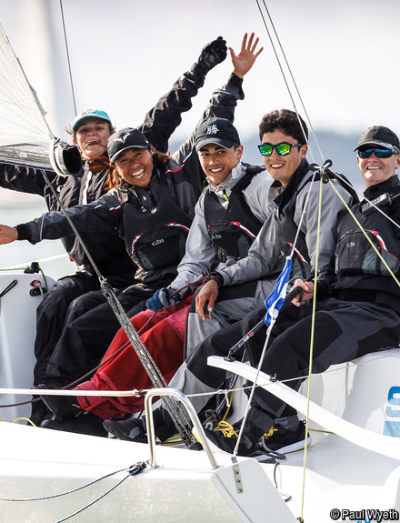 Group of sailors having fun smiling at camera on a race boat