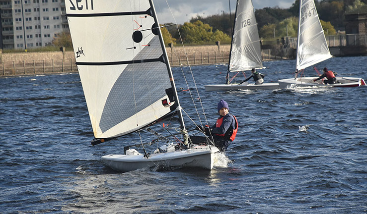 wide shots of sailors out on the lake during the winter months