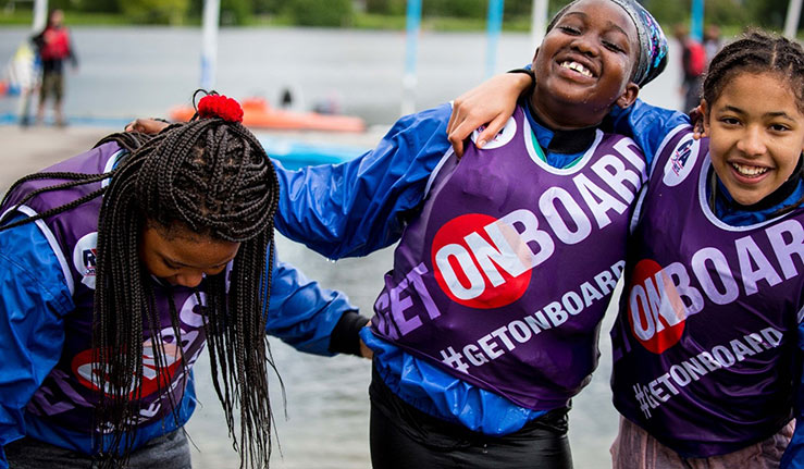 Mid shot of three children smiling in life vests