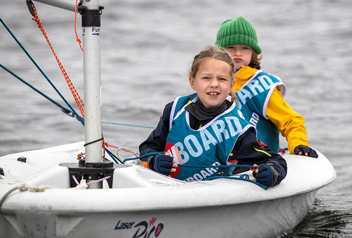 Two young children sailing a dinghy  