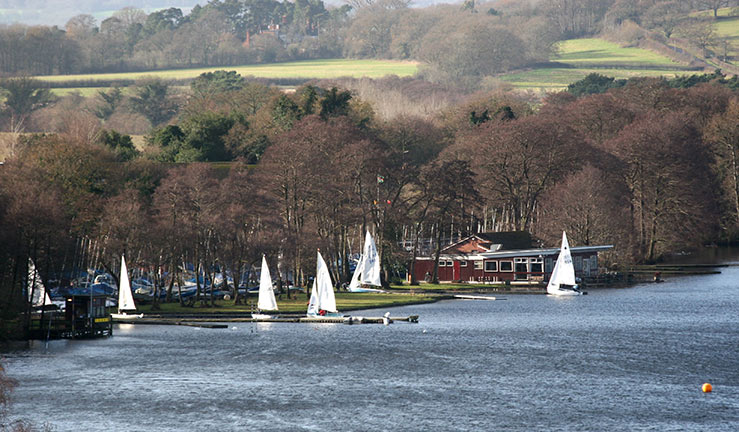 Geographical shot of Frensham Pond sailing club next to lake with sailing dinghies