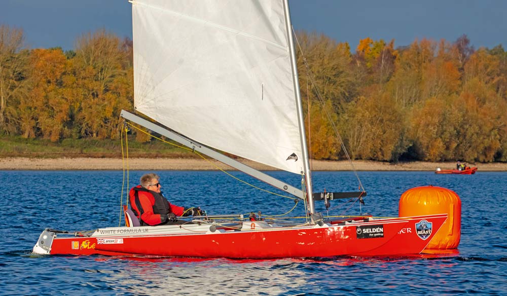man in read dinghy on blue waters