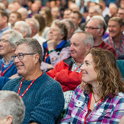 attendees smiling as they listen to a a lecture about training in sailing (probably sailors)