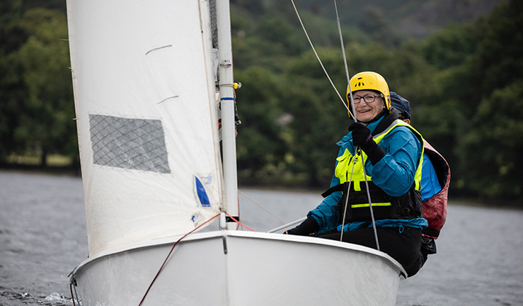 mid shot of smiling woman on a sailing dinghy 