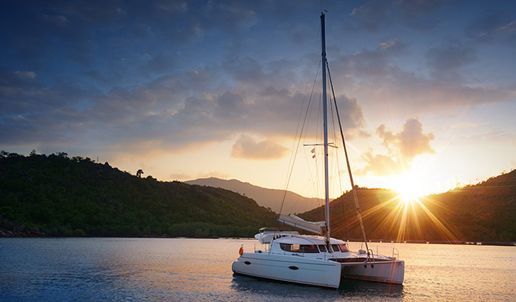 wide shot of sailing yacht on the water  during a peaceful sunset 