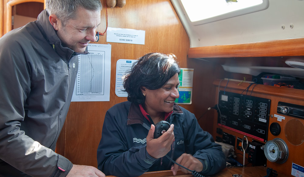 woman sat at chart table using fixed vhf radio