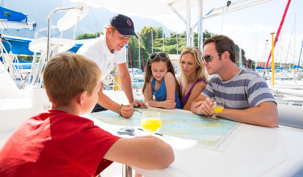Sunsail skipper carrying out chart briefing with family