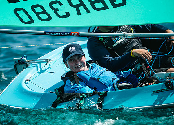 candid shot of parasailor sailing a dinghy on the open water