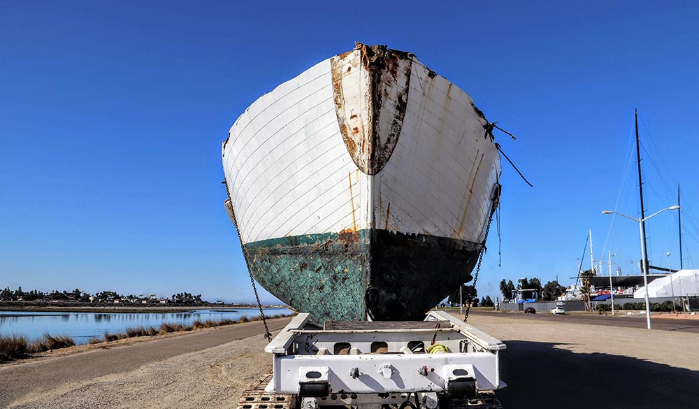 abandoned wrecked boat sitting on a trailer