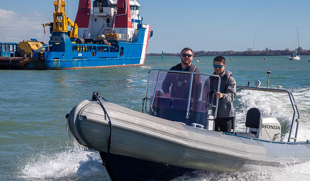 Wide shot of two men on powerboat