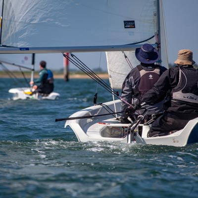 two people on a small sailing dinghy on the open sea