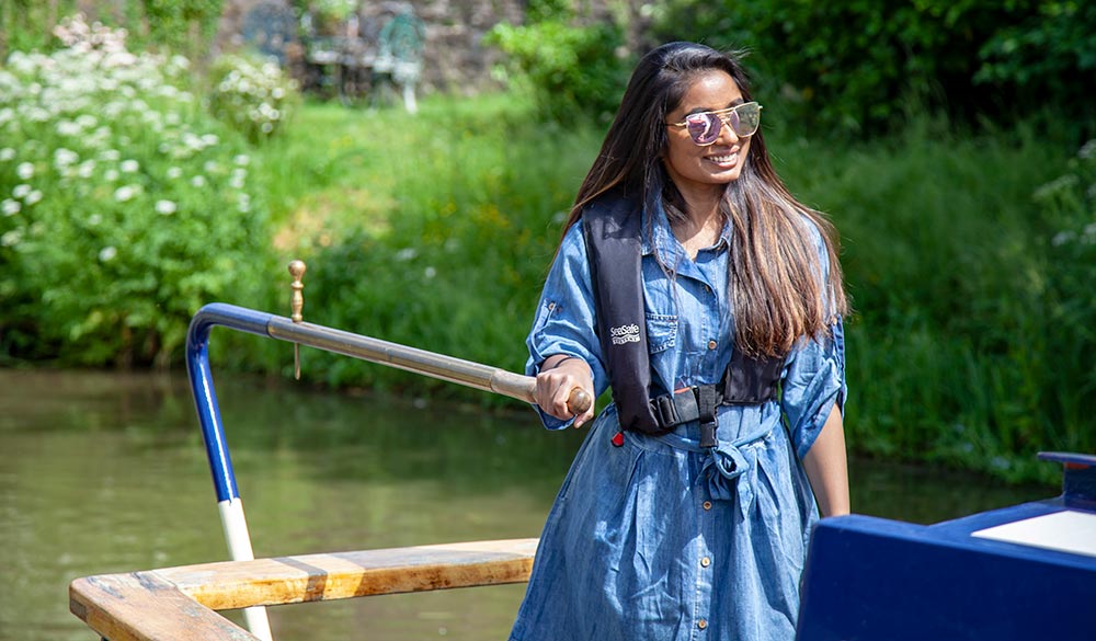 Wide shot of woman steering canal boat