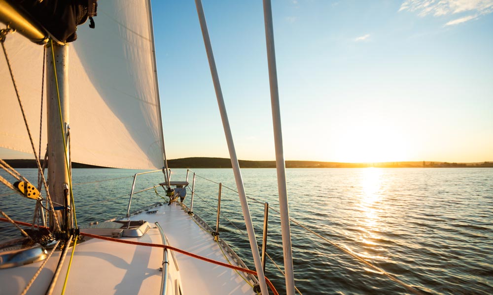 Yacht sailing at sunset on peaceful water