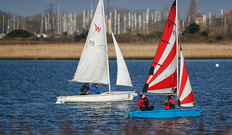 wide shot of two small sailing dinghies on a river