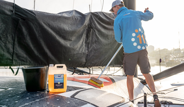 Wide shot of man cleaning boat with Eco works