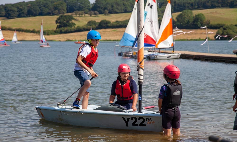 Kids sailing a dinghy across the water