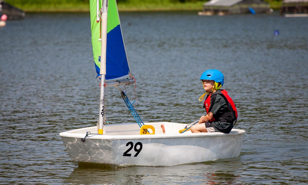 little boy sat in a dinghy 