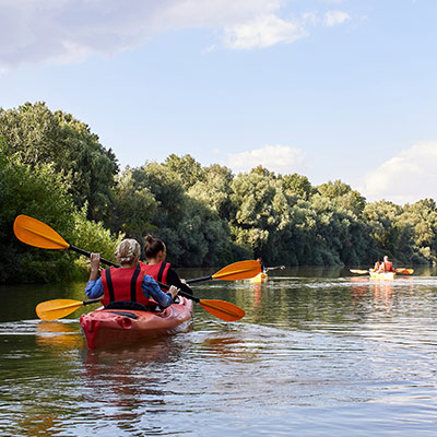 wide shot of two girls canoeing on a river