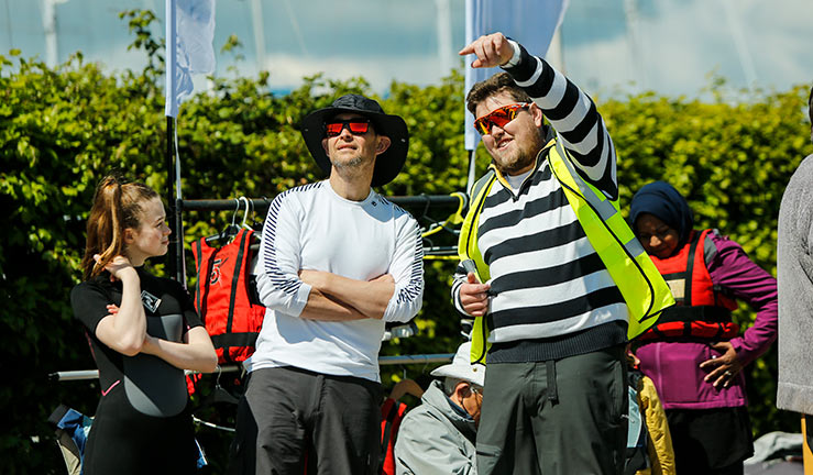 Candid shot of two volunteers pointing and talking about something at a sailing event