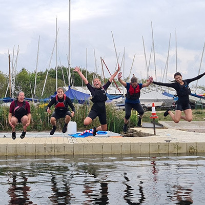 Whitefriars - group of four smiling children jumping into the water from jetty