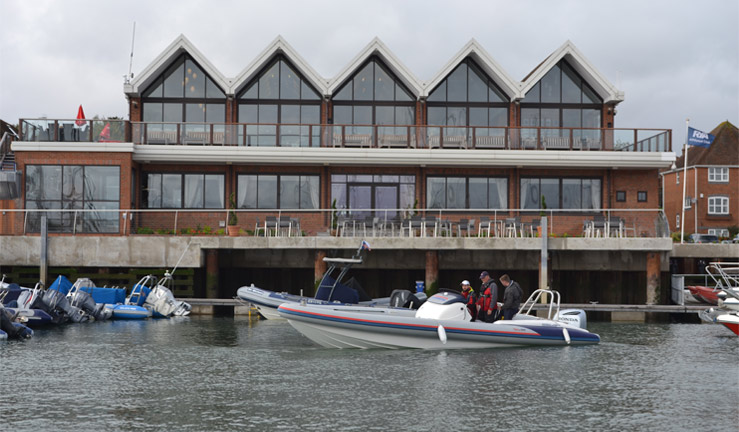 3 people driving a powerboat in a harbour