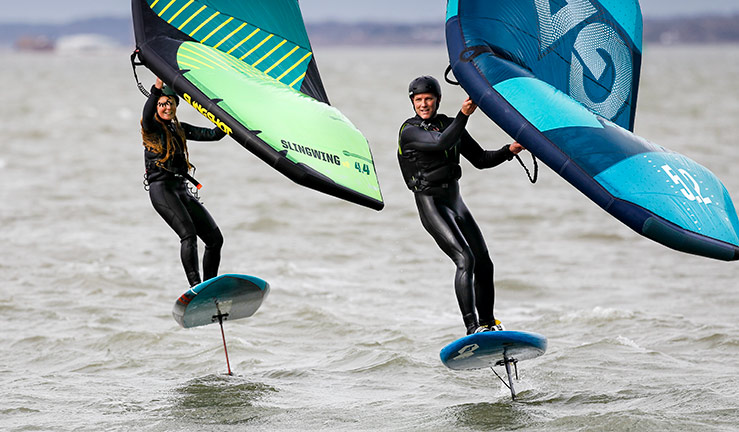 mid shot of people wing foiling on the open water
