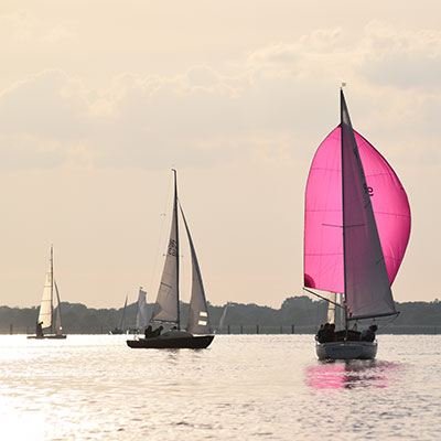 wide shot of a small yacht sailing off into the distance 