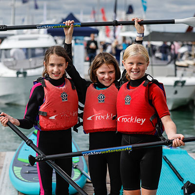 mid shot of three children holding paddles