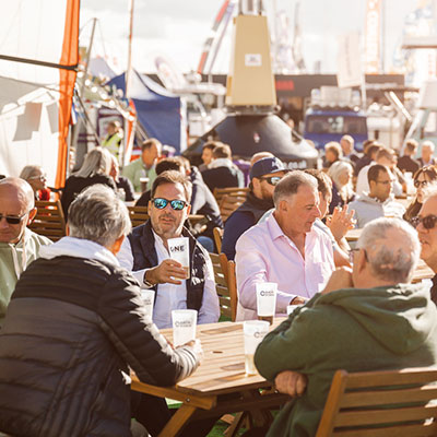 candid shot of a group of men sitting outside in the sun while drinking beer