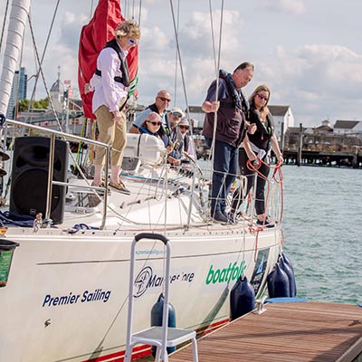 mid shot of a group of people standing a on a large yacht 