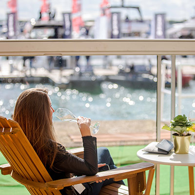 observational shot woman reclining in a lounger, drinking champagne in the sun