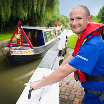 posed shot a volunteer smiling as the help open a lock for a canal boat