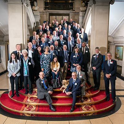 posed shot of all volunteer winners from 2022 standing a on a grand staircase at the award ceremony 