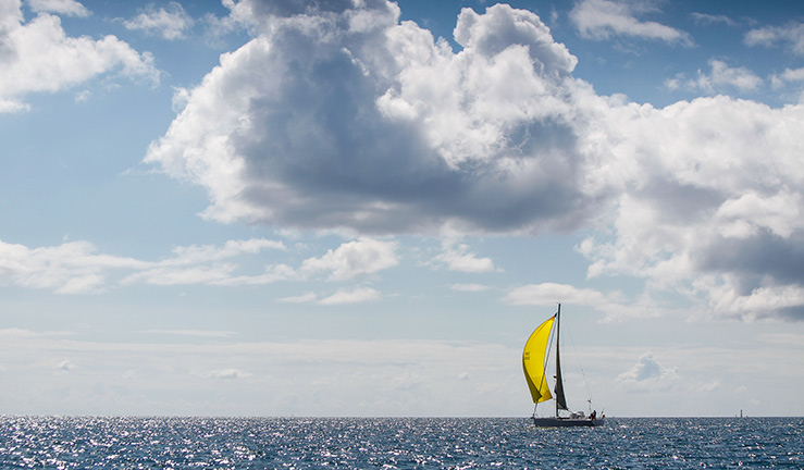 wide shot of sailing boat out on the water on a sunny day